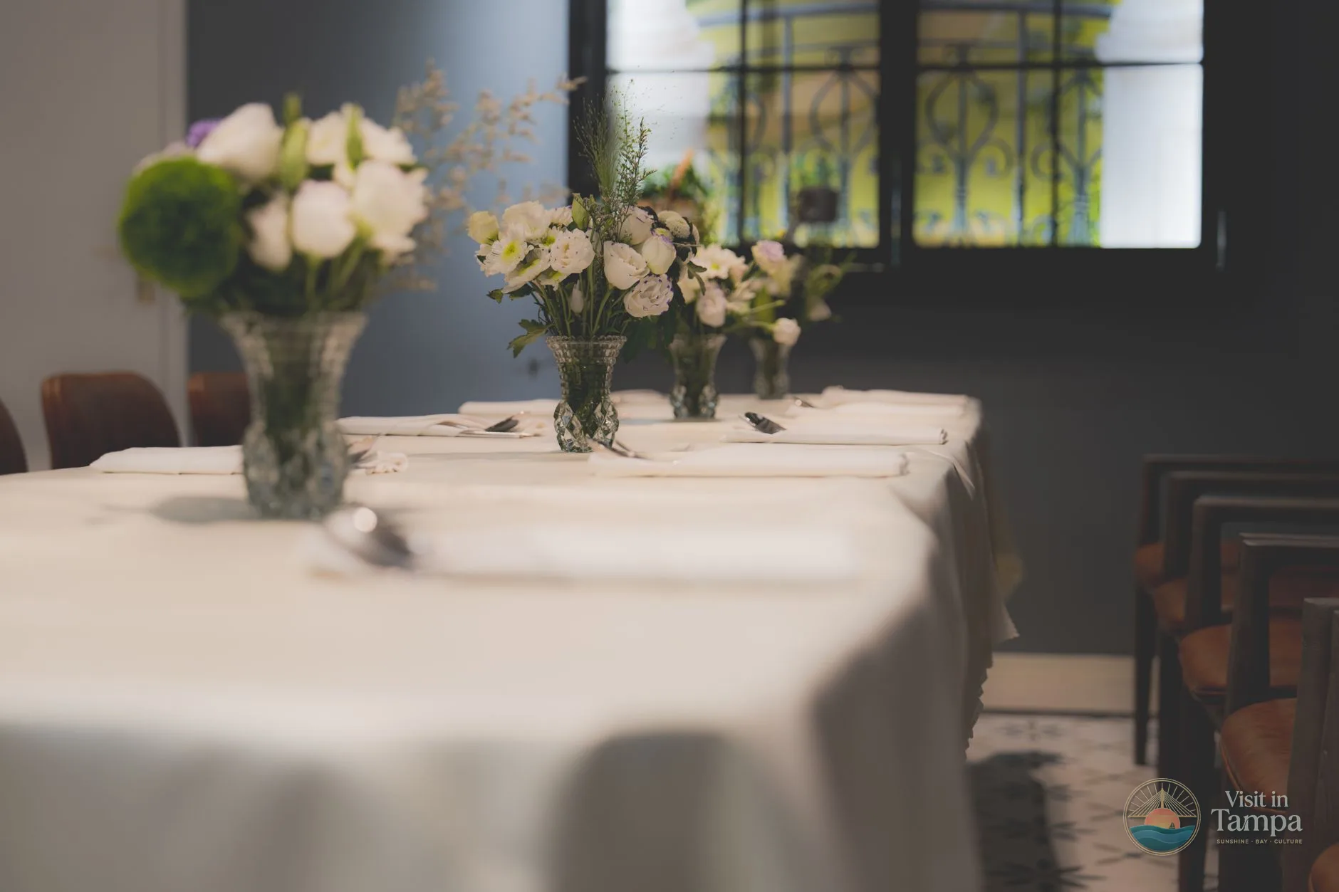 Lilac restaurant dining room at The Tampa EDITION with white tablecloths and bay-view windows