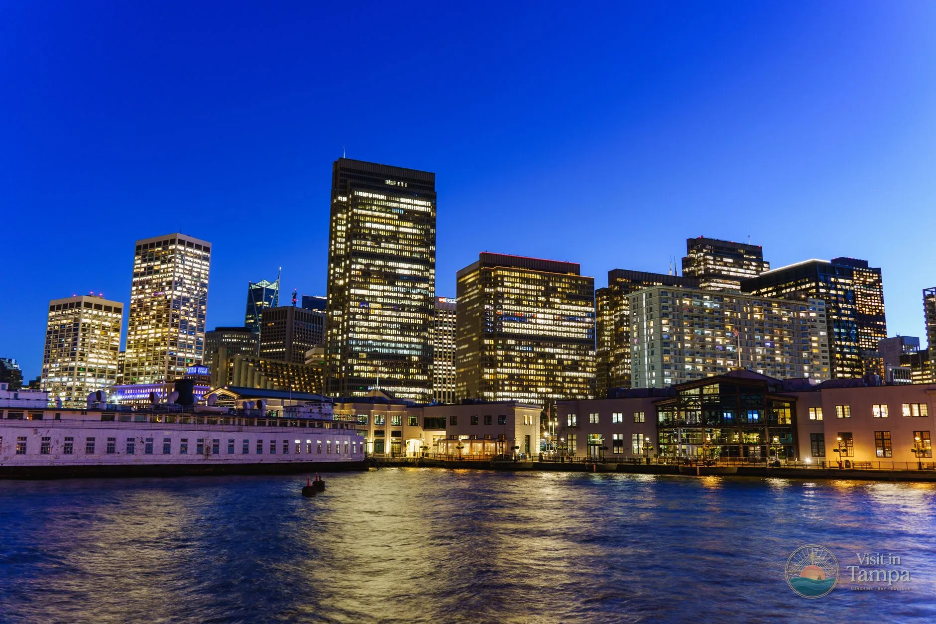 Water Street Tampa waterfront with the bay and downtown skyline at dusk